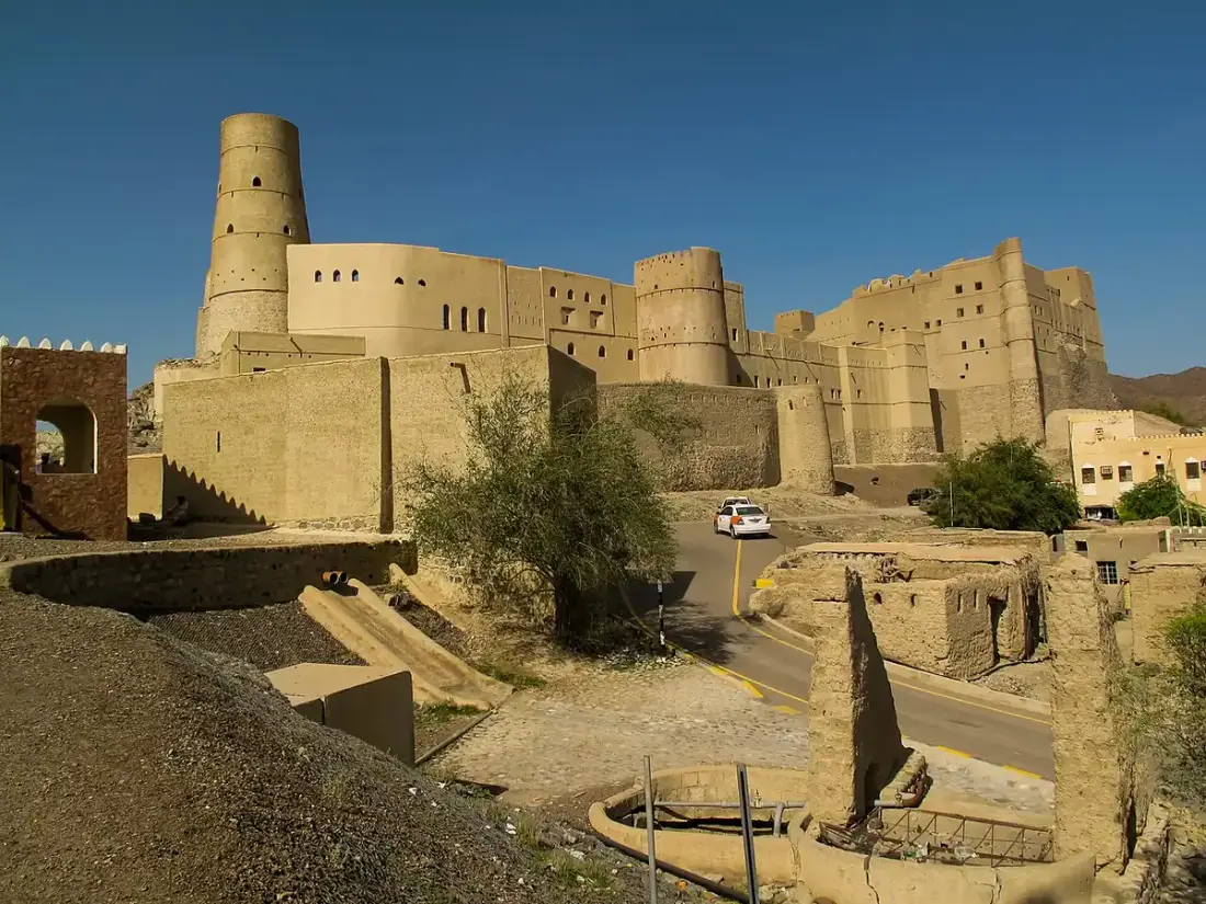 Le torri e le mura color sabbia del forte di Bahla sotto il cielo azzurro.