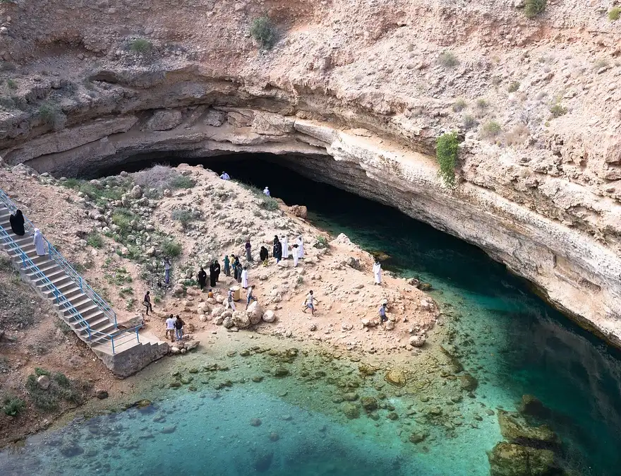Le acque turchesi del Bimmah Sinkhole viste dall’alto, con la scalinata d’accesso e visitatori.